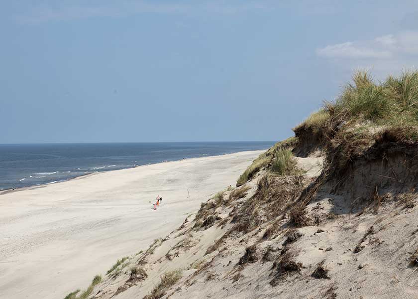 Sommerdag på stranden, så langt øjet skuer er der ikke en krusning på vandet - himlen er høj, vejret er skønt