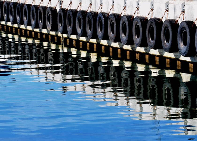 Kajerne i Hvide Sande beklædt med fendere for ikke at skade skibene når de ligger ved kajen, her spejler de sig flot i vandet