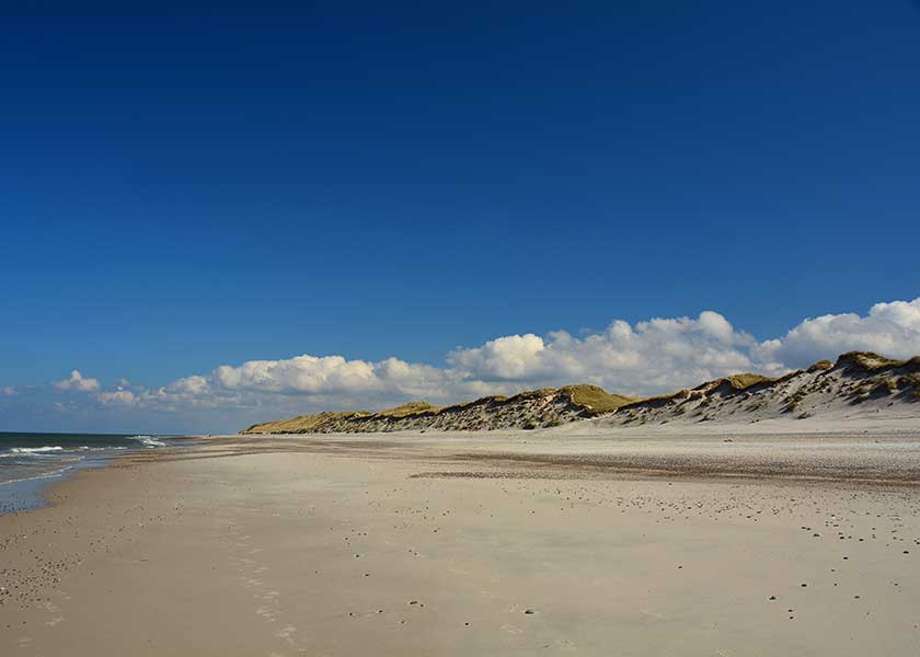 Sand, strand og klitter så langt øjet rækker, de vidtstrakte strande syntes endeløse flot flankeret af de flotter sommerskyer