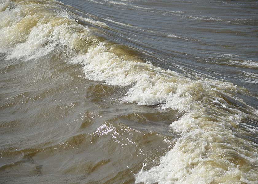 Bølgerne ruller tungt forbi molerne, vinden har været kraftig, vandet er stadig meget grumset