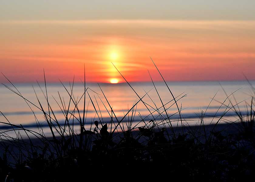 Solen går ned i havet efter en dejlig varm sommerdag i ferielandet stemningen er intens