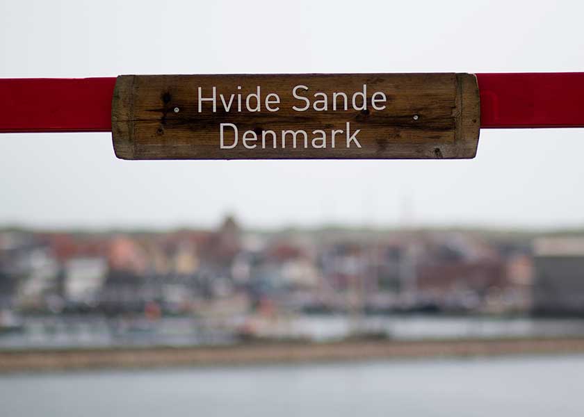 Navnebrædtet med teksten Hvide Sande placeret på troldebjerg med udsigt til sydhavnen