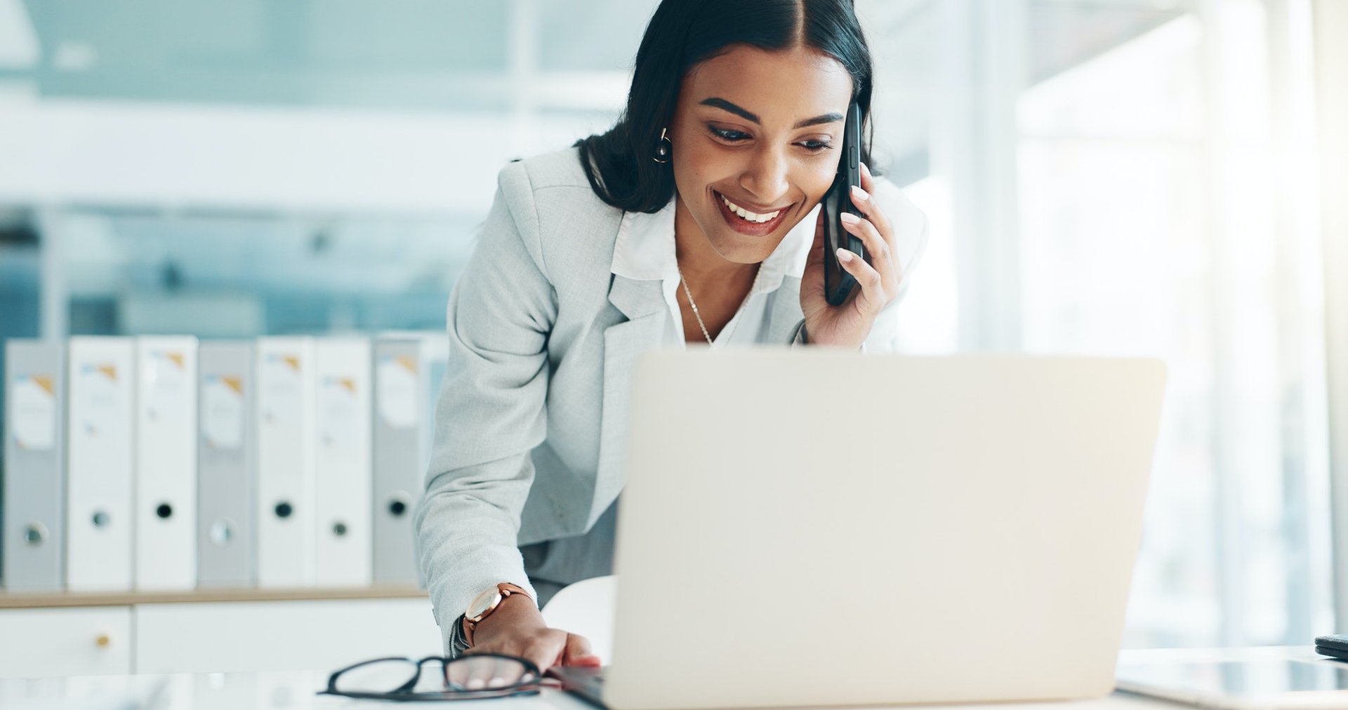 Phone call, laptop and business Indian woman in office for planning, discussion and communication.