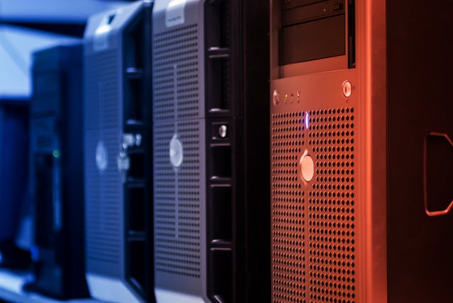 Close-up view of several computer servers lined up in a row, with a focus on the front panels and ventilation grills.
