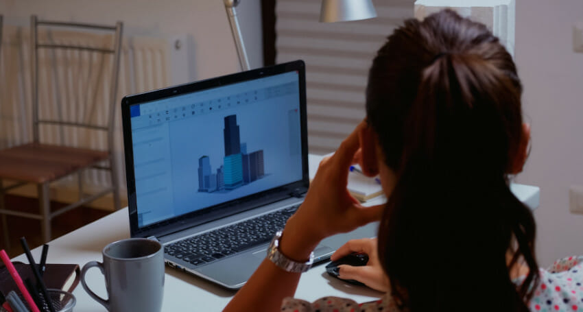 A woman using design software on a computer screen.