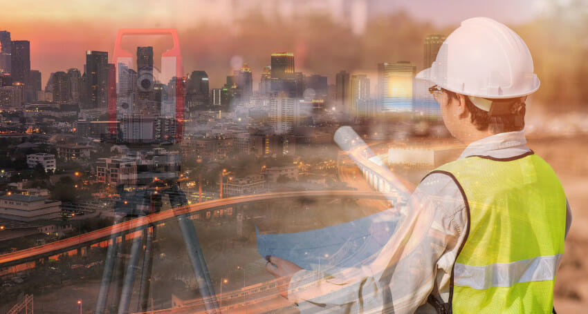A man in a hard hat is looking at a cityscape.