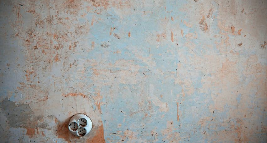 A concrete wall with an electrical plug socket