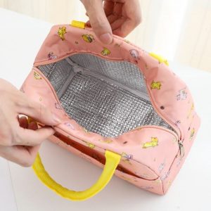 Sac isotherme rose avec motifs colorés, intérieur en aluminium pour une meilleure isolation, doté de poignées jaunes pour un transport facile.