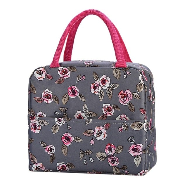 Sac isotherme à motif floral gris et rose, avec poignées roses et compartiment extérieur pratique.