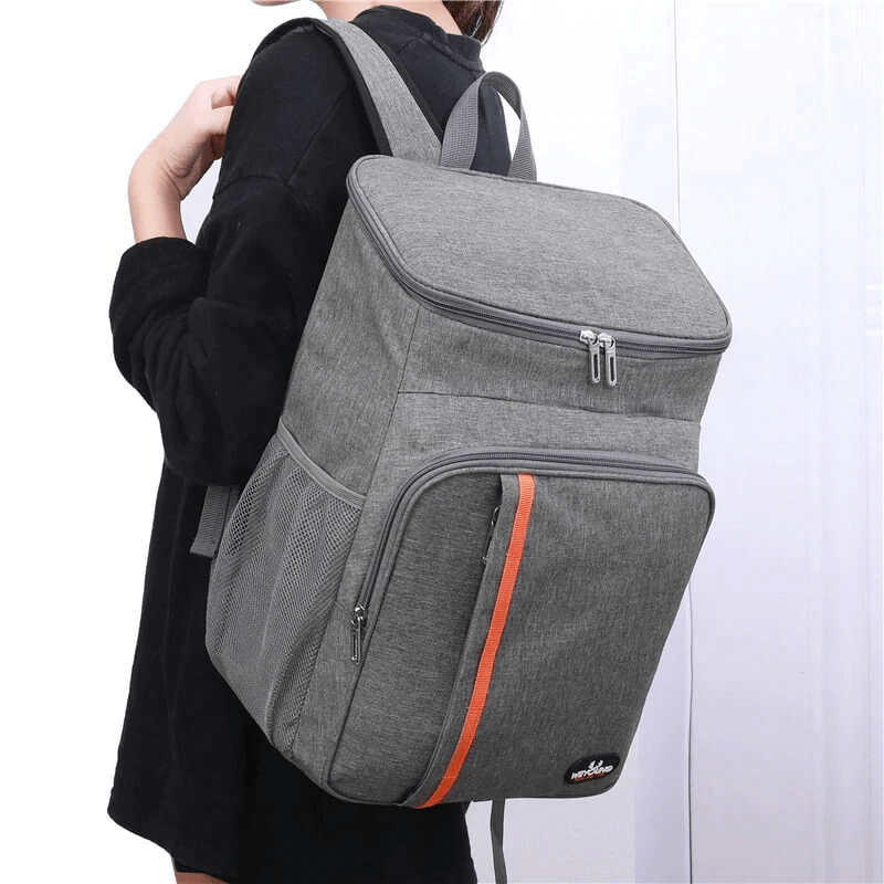 Sac à dos isotherme gris avec une poche latérale en mesh et une fermeture éclair, idéal pour transporter des aliments et des boissons en maintenant leur température.