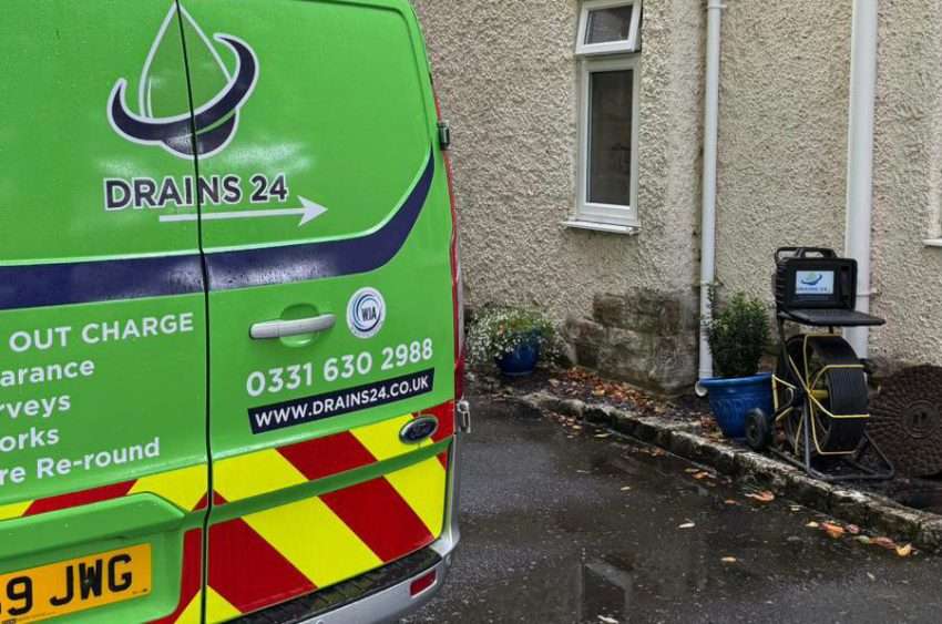 A drainage engineer in Salisbury using CCTV inspection equipment in a garden to check underground pipes, illustrating how CCTV drain surveys detect hidden drainage issues early.