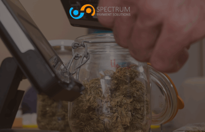 A person paying with a credit card at a cannabis dispensary