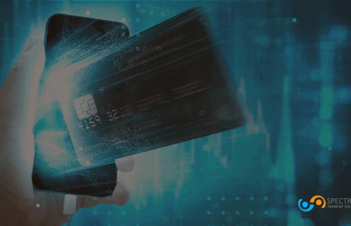 Hand holding smartphone with digital credit card graphic overlay, representing secure online payment processing by Spectrum Payment Solutions