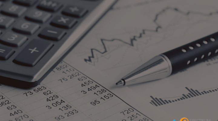 A financial report with a pen and calculator, representing data analysis and financial risk management for high-risk merchant accounts with Spectrum Payment Solutions.