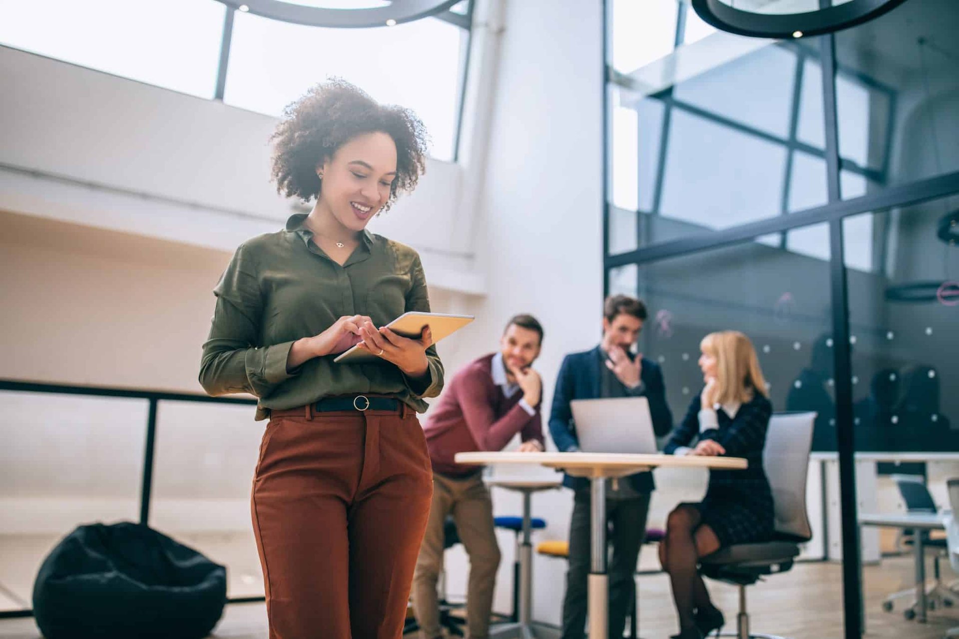 woman on tablet with coworkers in background