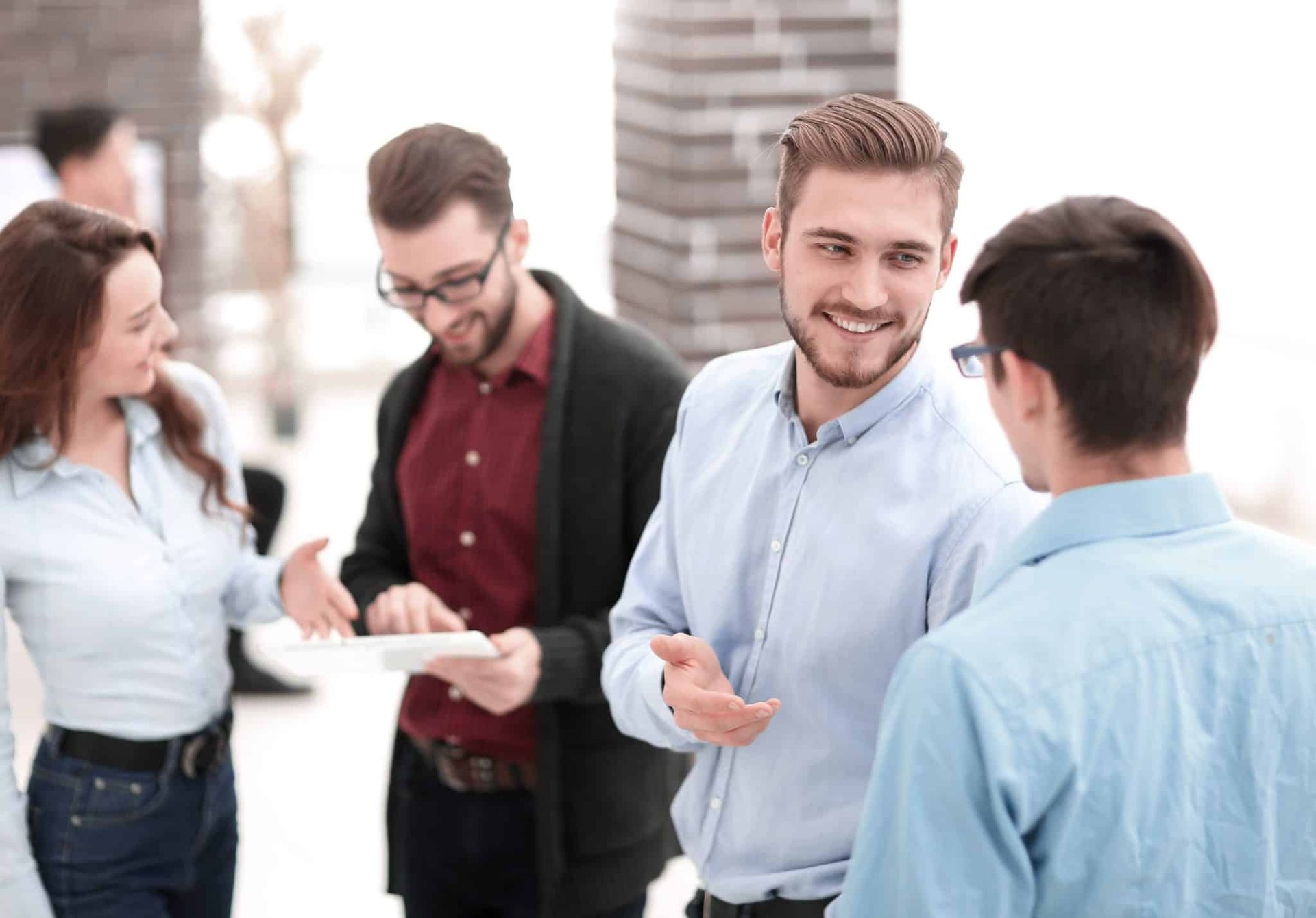 A group of people talking to each other in an office.