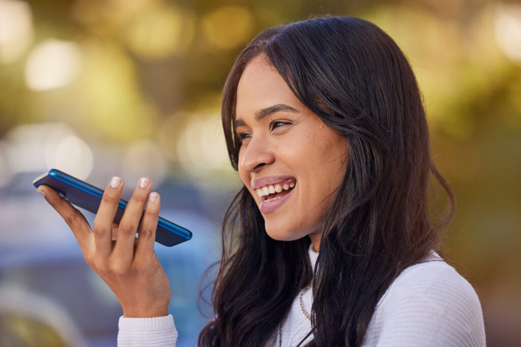 Woman using voice search on her smartphone outdoors