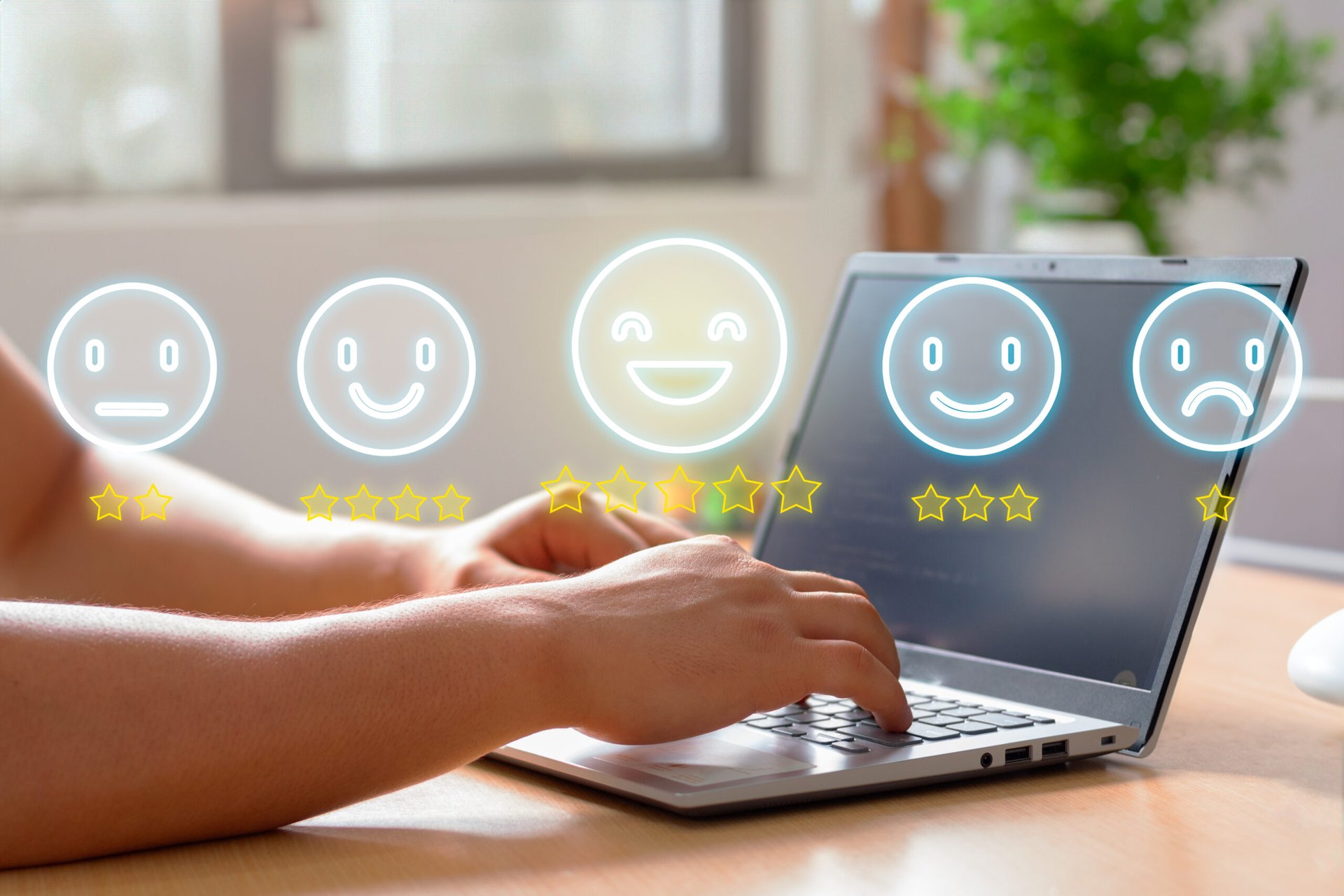 A person typing on a laptop, with customer review ratings represented by smiling and neutral faces above the screen.