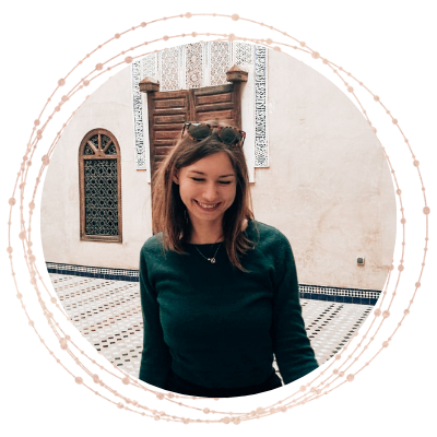 Daria Kamińska_Pracownia Szczęścia_zdjęcie profilowe Uśmiechnięta kobieta przed ozdobnym kołem, przedstawiająca terapię par i poradnictwo psychologiczne.