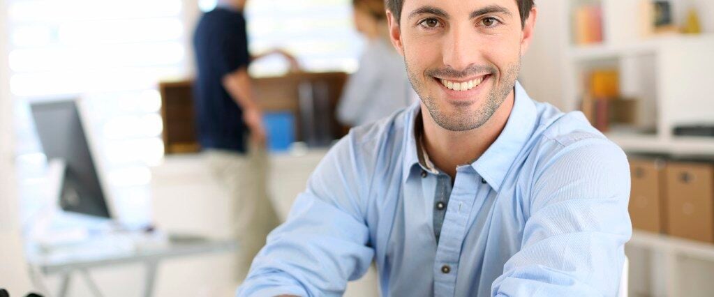 Smiling man with arms crossed in office img-26