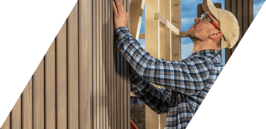 Man installing siding on a building's exterior.