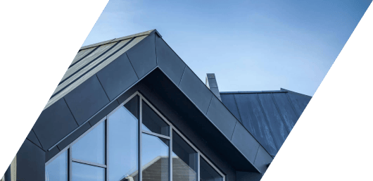 Modern architectural design with sharp angles and a mix of glass and metal materials against a clear sky.