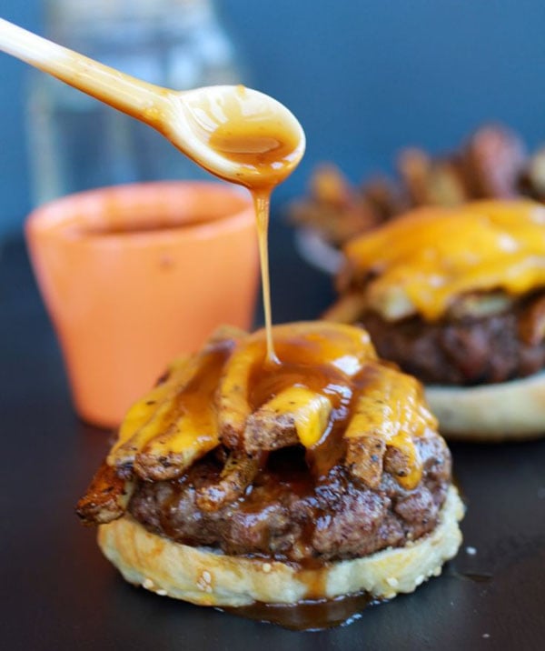 The burgers are being drizzled with caramel sauce for awesome visual suggestions.