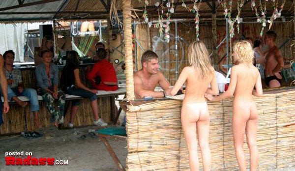 A group of people standing at a bar.