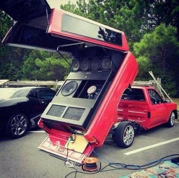 A red truck with a large speaker in the back that screams