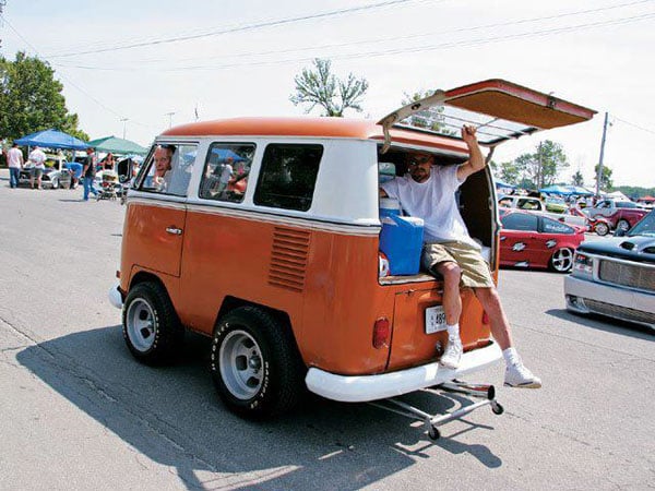 A man chilling in the back of a cool VW bus.