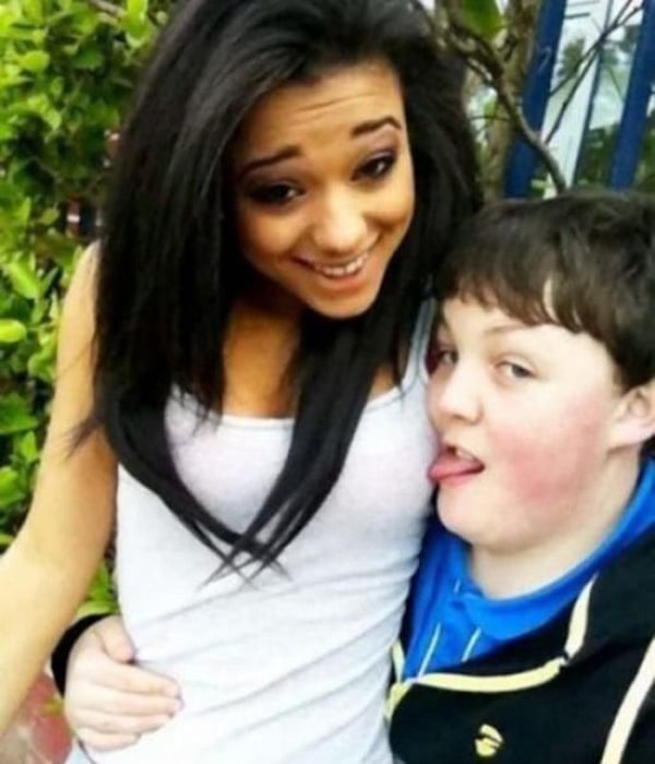 A girl is posing for a picture with a boy from the