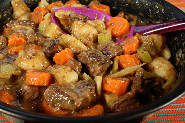 A comforting pot of stew featuring delicious carrots and potatoes.