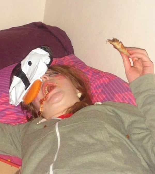 A woman, with a pizza in her mouth, illustrating the phrase
