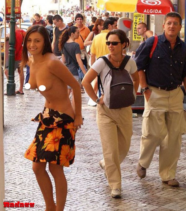 A woman in a skirt is walking down the street accompanied by another woman.