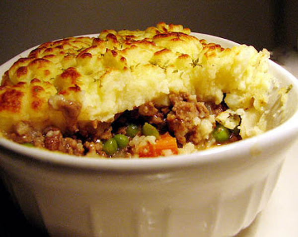 A comforting dish made with meat and vegetables served in a white bowl.