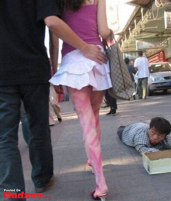 A woman walking down the street sees a man laying on the ground and exclaims,