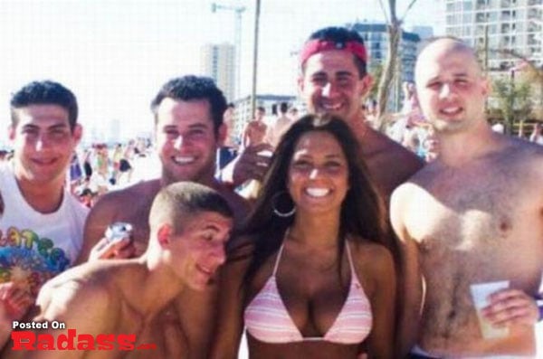 A group of people posing for a picture on the beach.