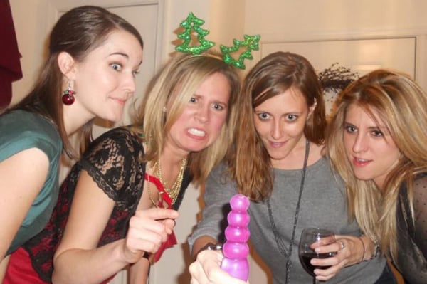 A group of women are posing for a picture with a purple toy in