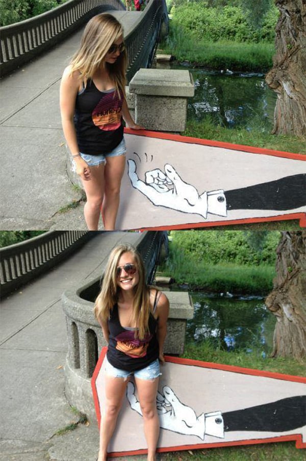A woman is posing next to a painting of a hand, expressing hesitation.