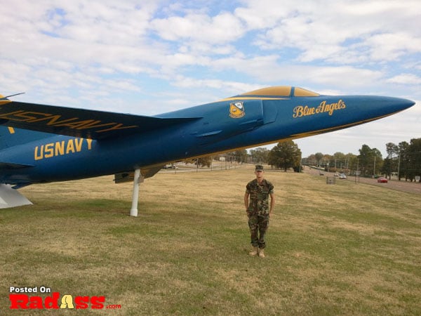 A man standing in front of a blue jet, an American hero.