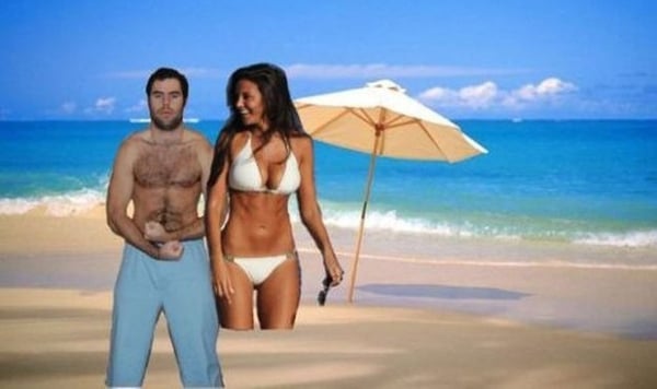 A couple posing by the seaside with an umbrella.