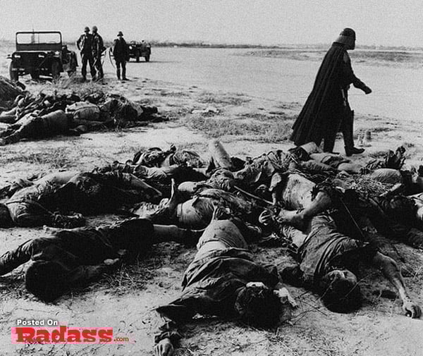 Super heroes lying dead in front of a jeep.
