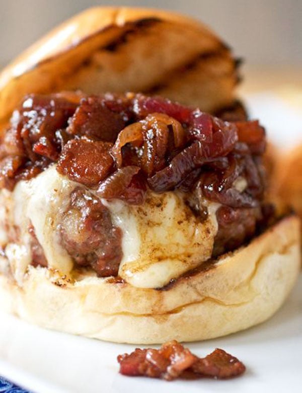 An awesome burger featuring onions and cheese on a plate.