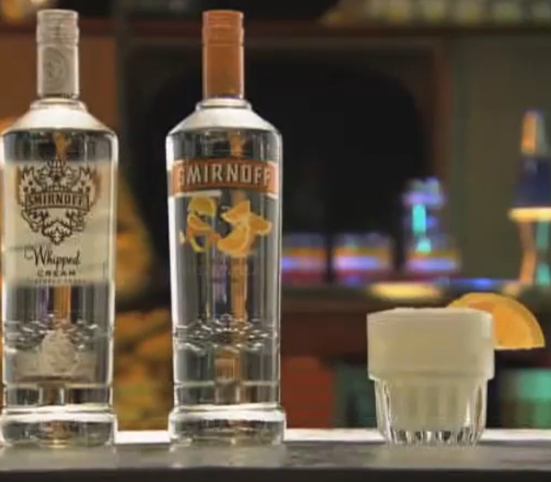 A bottle of vodka and a glass of orange juice, demonstrating drinking etiquette at home.