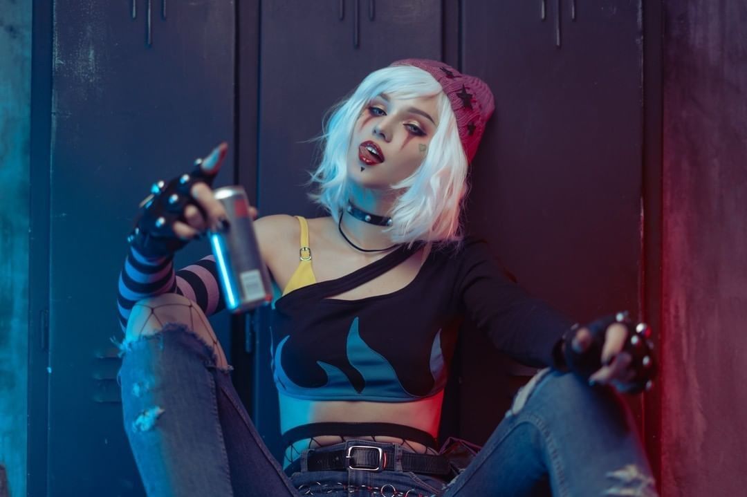 A woman sitting on the floor holding a can of soda.