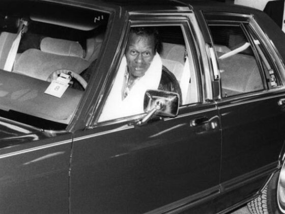 A man, embodying the true spirit of Legends of Rock N Roll, sits confidently in the driver's seat of a car.