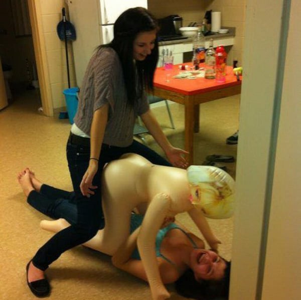 Two women playfully interact with a mannequin, expressing a lighthearted
