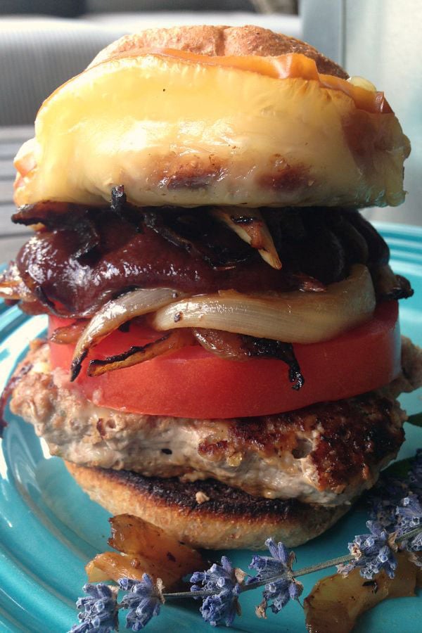 An awesome burger on a blue plate.