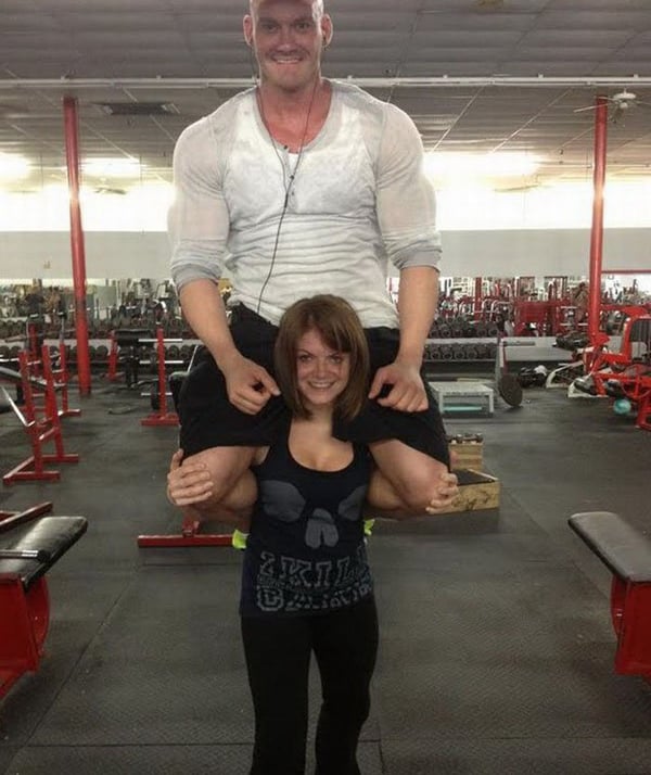 A man posing with a woman in a gym, showcasing their chemistry as potential dating partners in an