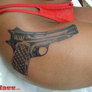 A woman with a gun tattoo on her thigh lives by the motto "32 People That Are Packing For Life.